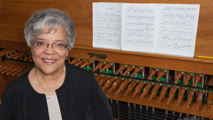 Julianne Vanden Wyngaard sitting in front of a carillon